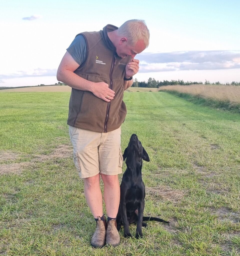 Hund står korrekt ved ejerens side efter kommandoen "på plads".